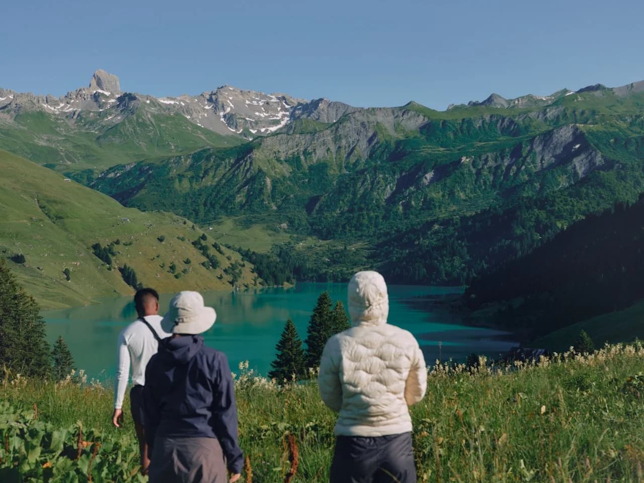 Group of people hiking toward a mountain lake